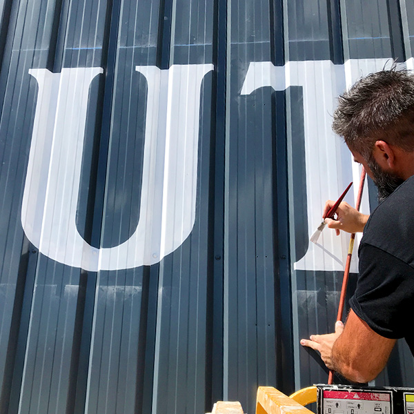 rotulación-a-mano-con-pintura-en-taller-nave-industrial